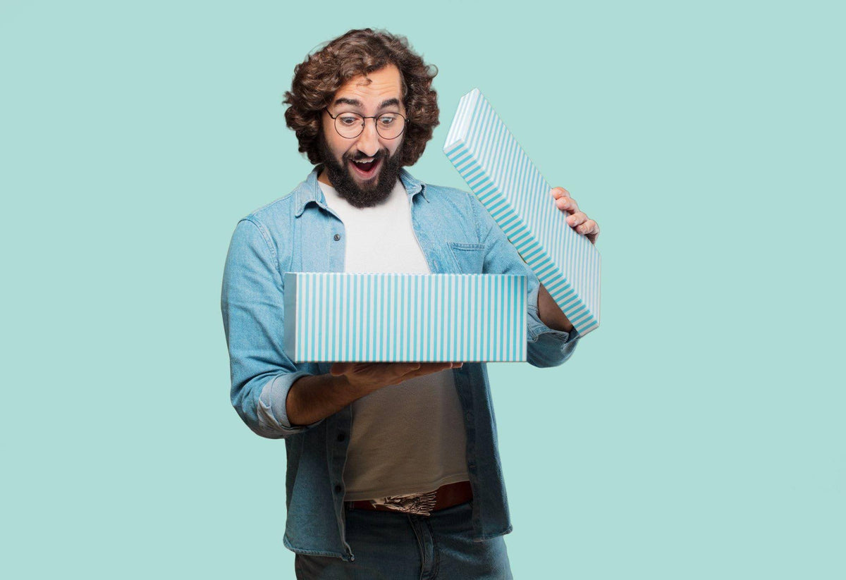 A man with a surprised expression holds a box indicating unexpected contents or a surprise gift